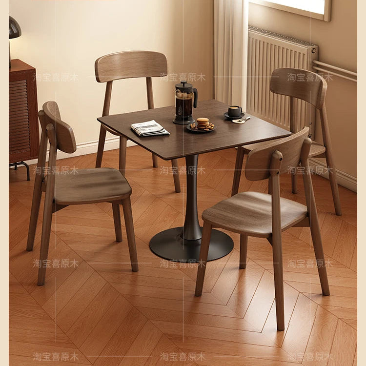 Dining table set with four chairs in a room with wooden flooring and a radiator.